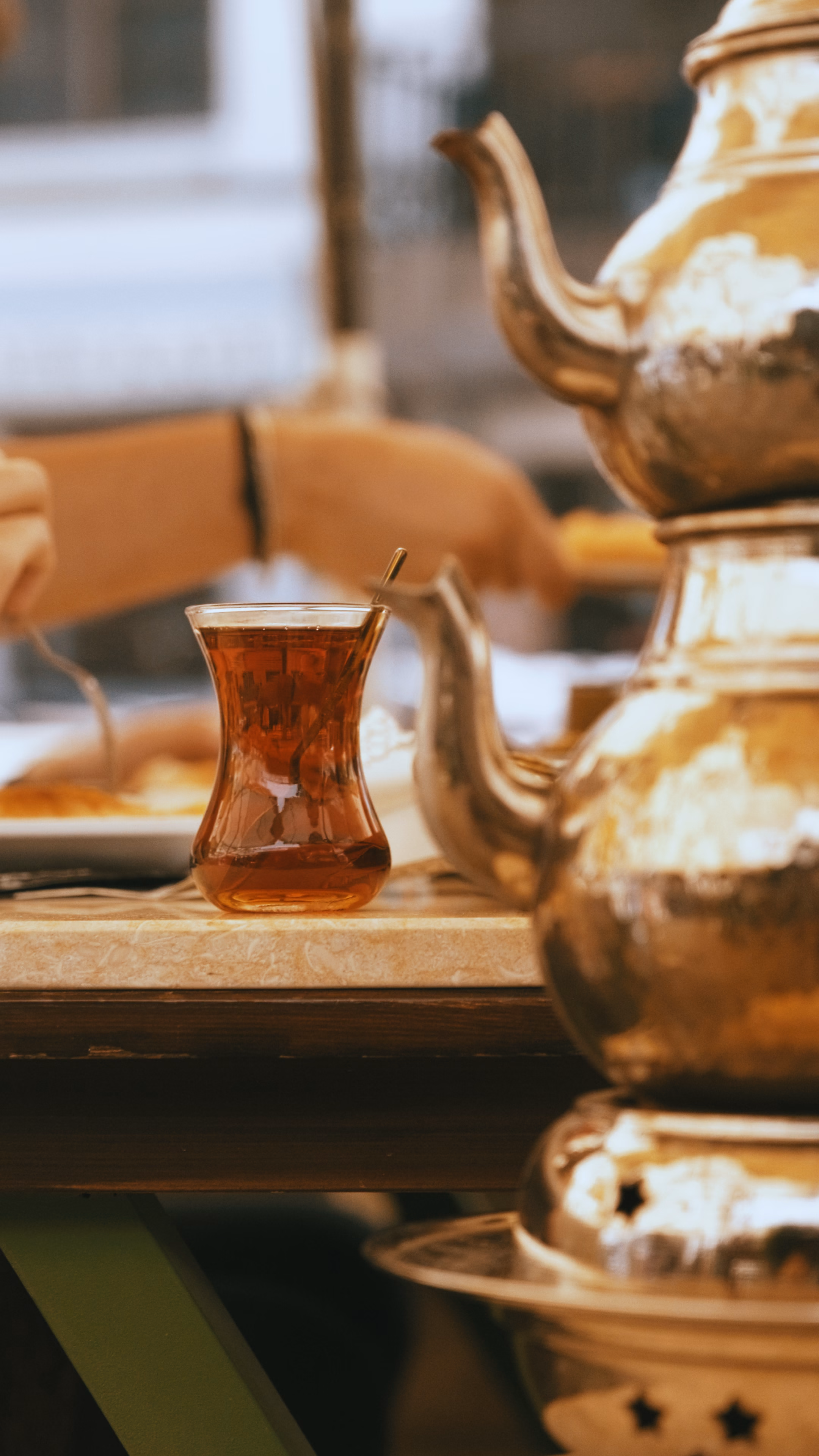 Bakır çaydanlığın önünde ince belli bardakta demlenmiş çay